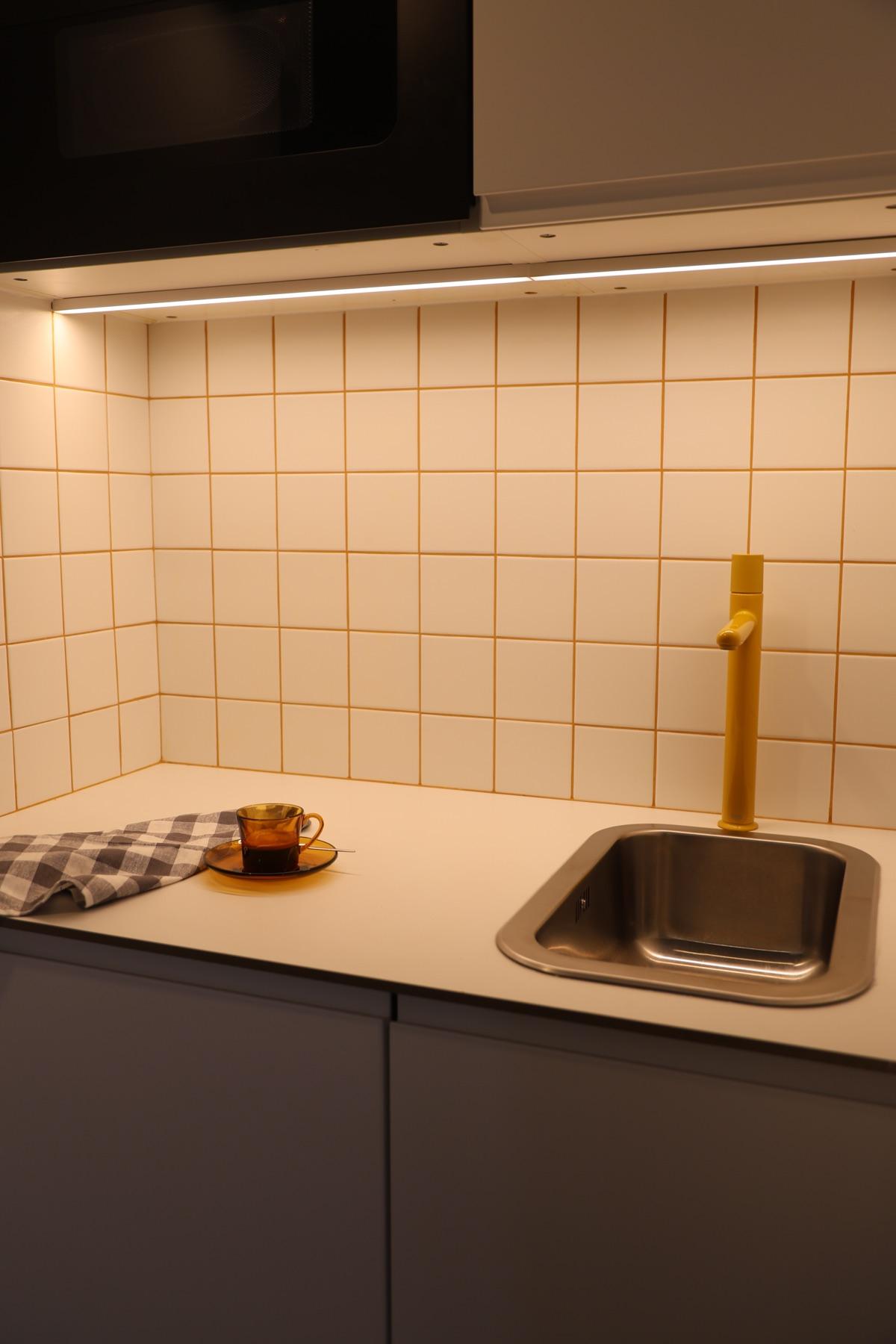 Kitchen with white tiles and warm details