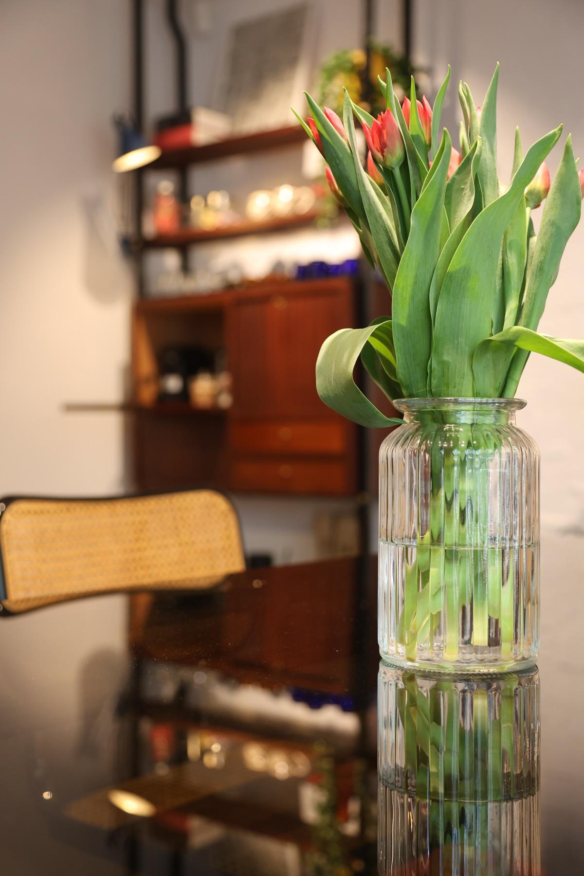 Tulips in a vase on a glass table