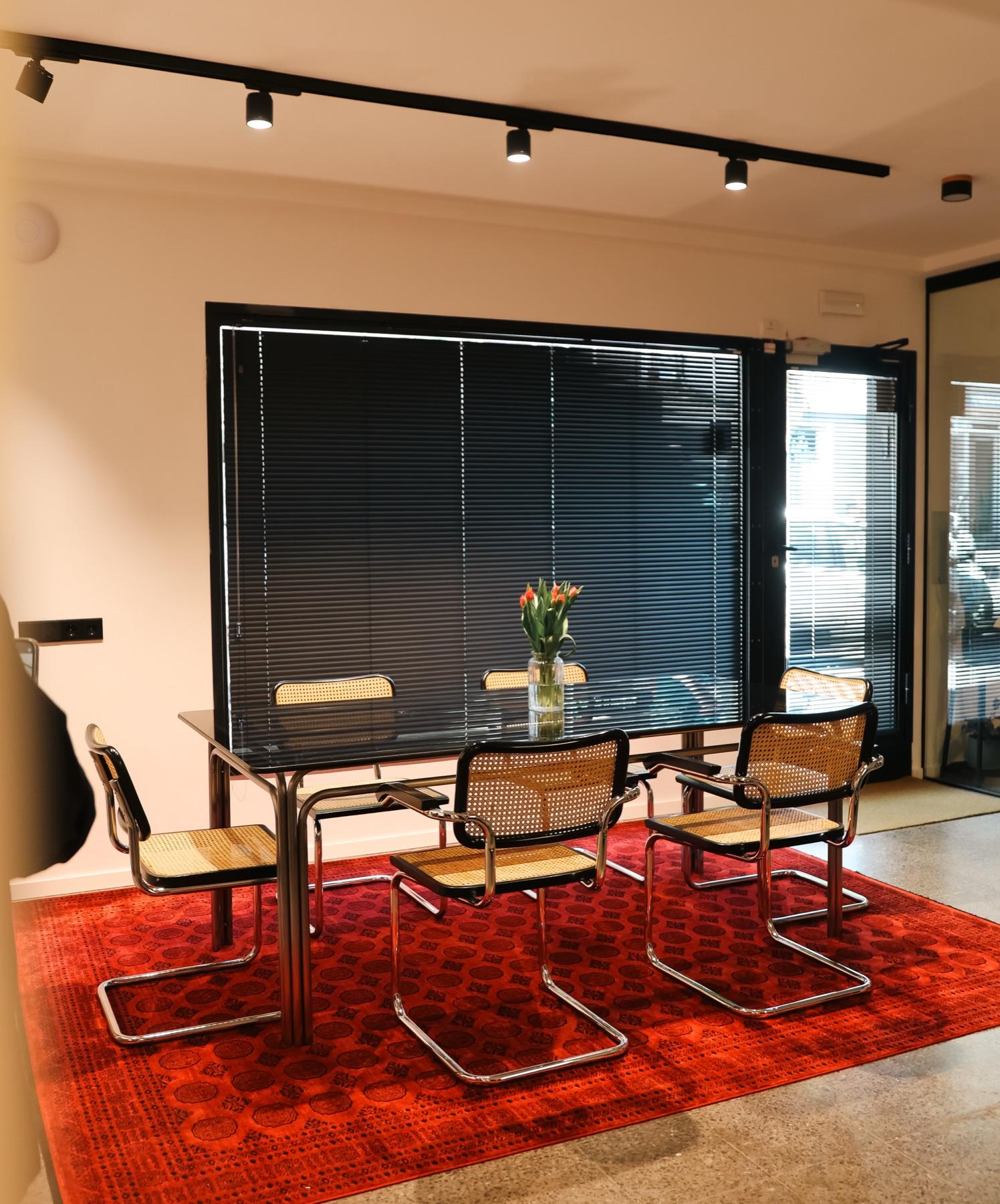 Meeting table with cane chairs on a red rug